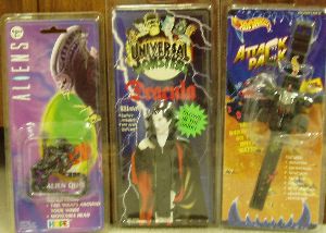 Three different toy watches including Dracula, Alien, and Hot Wheels Attack Pack Car.